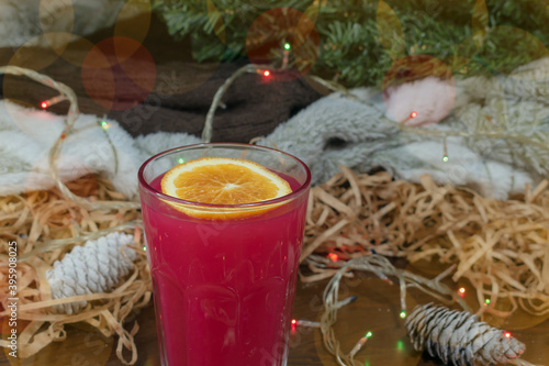 A glass of rose warming drink with a slice of orange. Close-up. 