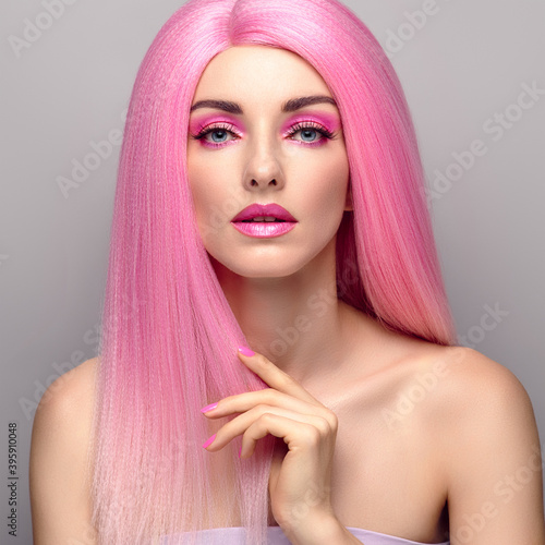 Beauty Fashion woman with Colorful Pink Dyed Hair. Girl with blue eyes, perfect Makeup and Hairstyle. Beautiful smiling model portrait, fashionable pink make up, hair. Skincare concept