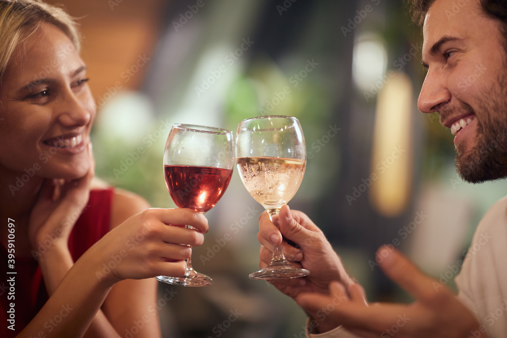 beautiful caucasian couple toasting with wine at dinner, looking each other, smiling. beautiful caucasian couple toasting with wine at dinner, looking each other, smiling.