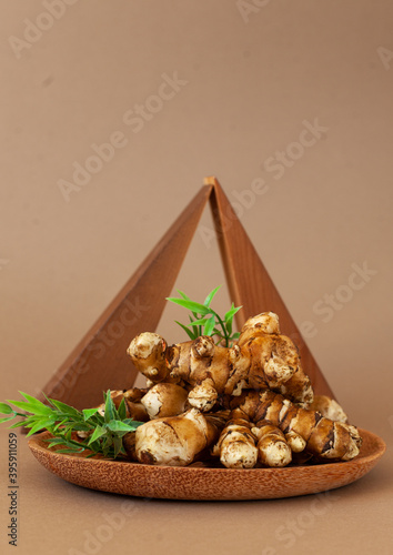 Jerusalem artichoke on brown  background. Topinambur isolat, photo