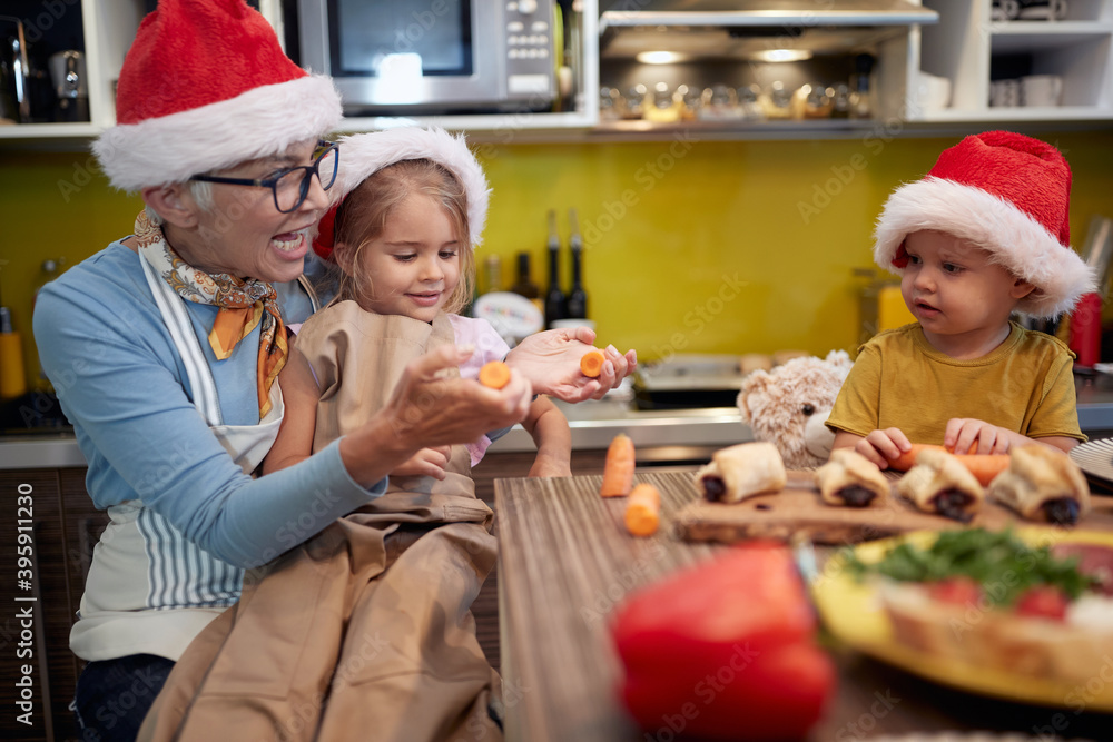 Grandma and grandchildren preparing Xmas meal in the kitchen together. Christmas, family, together Grandma and grandchildren preparing Xmas meal in the kitchen together. Christmas, family, together