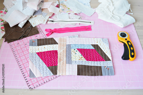Fotografia Working process: colorful quilt, zipper, quilting ruler, fabric scraps, cutting