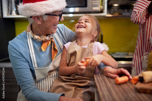 Happy grandma and granddaughter together in the kitchen in festive christmas atmosphere. Christmas  family  together