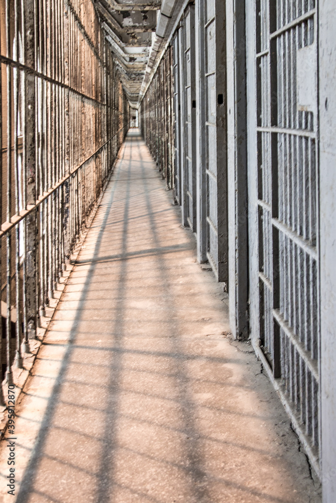Abandoned Prison Interior. Row of empty cells on cell block of abandoned prison in vertical orientation Abandoned Prison Interior. Row of empty cells on cell block of abandoned prison in vertical orientation