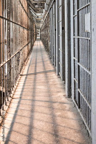 Abandoned Prison Interior. Row of empty cells on cell block of abandoned prison in vertical orientation