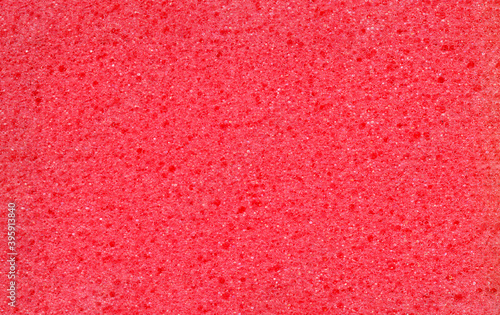 Texture of red dishwashing sponge. Abstract red background.