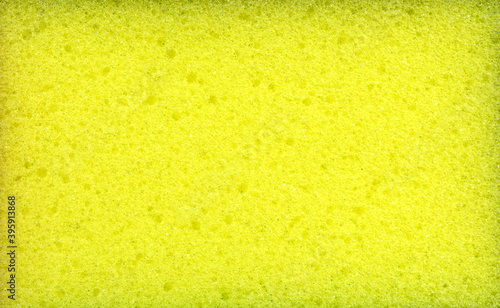 Texture of yellow dishwashing sponge. Abstract yellow background.