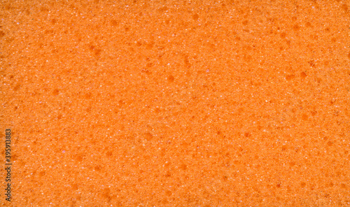 Texture of orange dishwashing sponge. Abstract ornge background.