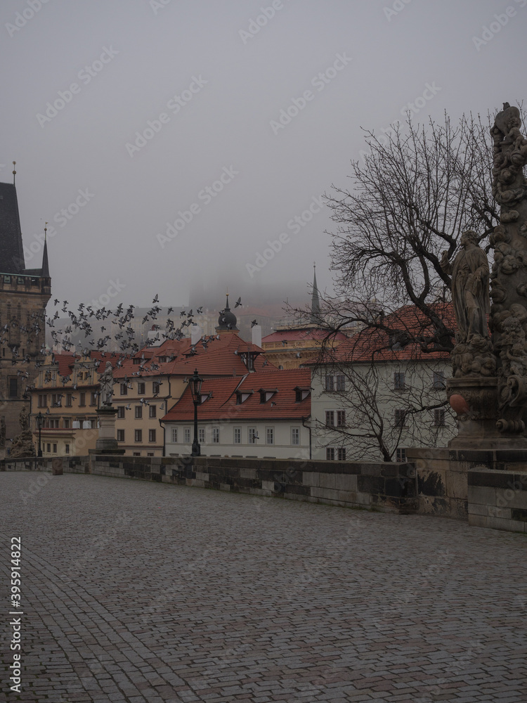 Obraz premium Prague Castle and Lesser Town as seen through the fog frm Charles Bridge in Prague on an autumn morning