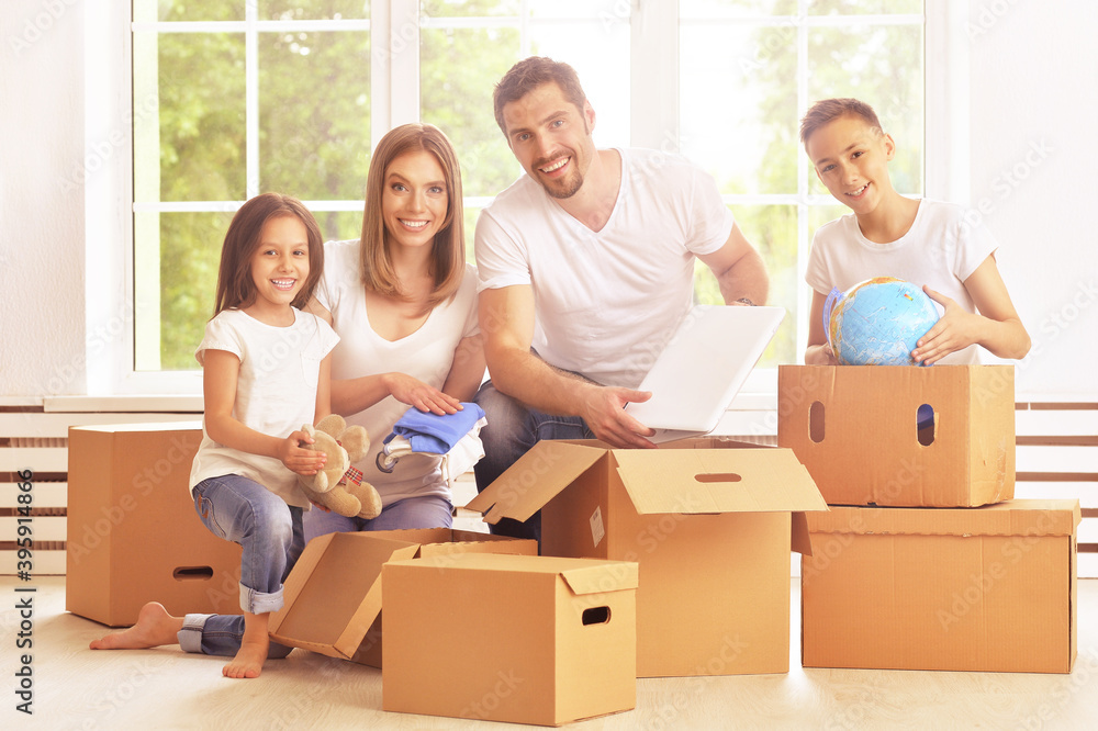 Happy family in a new house taking things apart Happy family in a new house taking things apart