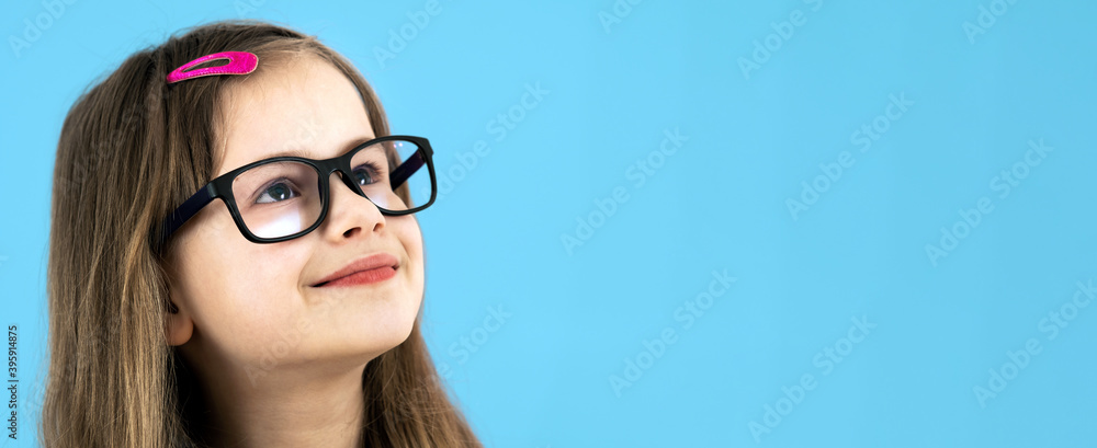 Close up portrait of a child school girl wearing looking glasses isolated on blue background. Close up portrait of a child school girl wearing looking glasses isolated on blue background.