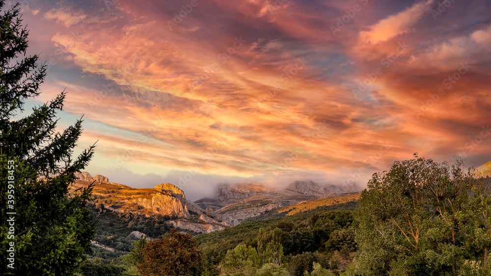 Nice cloudy sunset over the foggy mountains