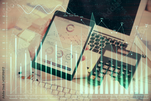 Double exposure of man's hands holding and using a digital device and forex graph drawing. Financial market concept.