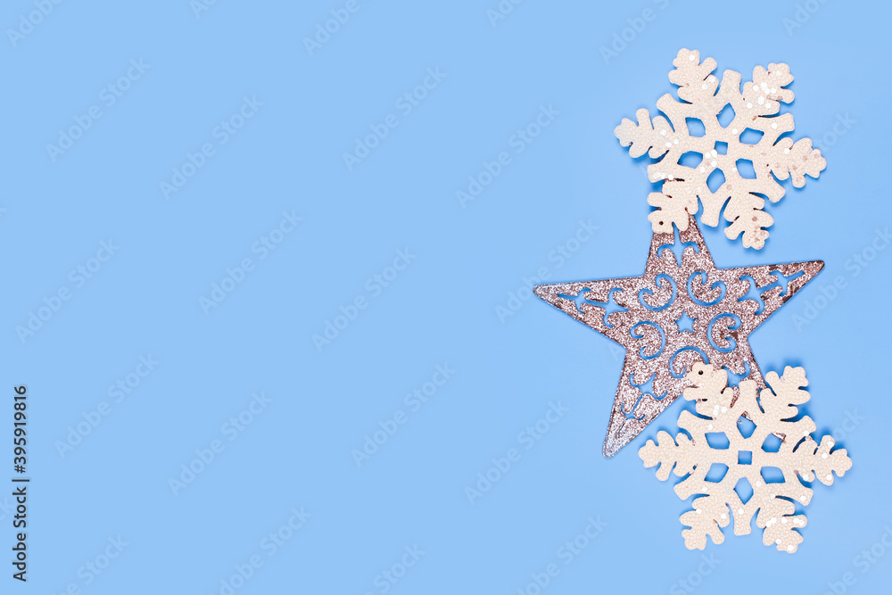 Christmas snowflakes and star frame on blue table. Top view. Free place for product or text.