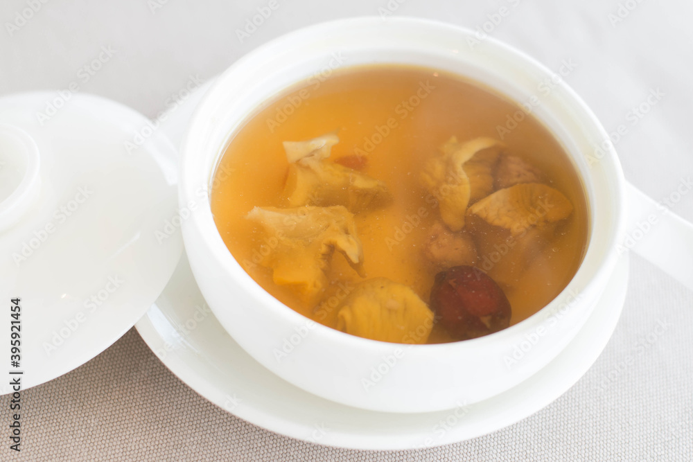 an appetizer of Double-boiled Conch and Red Date Soup served in a white china bowl an appetizer of Double-boiled Conch and Red Date Soup served in a white china bowl
