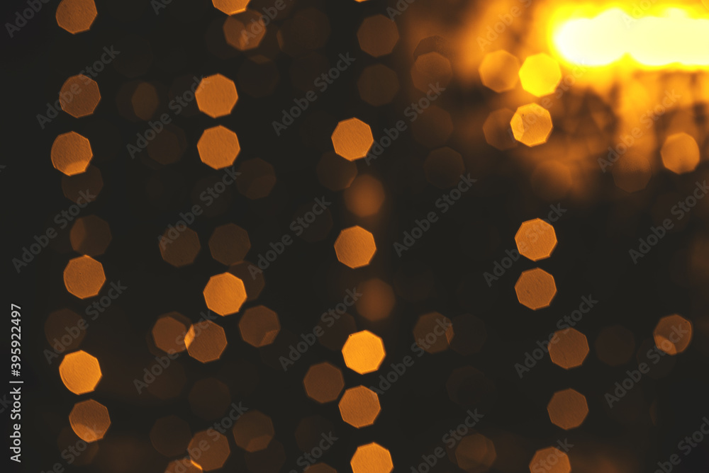 Gold abstraction background. Yellow bokeh lights on a dark background. Blurred light
