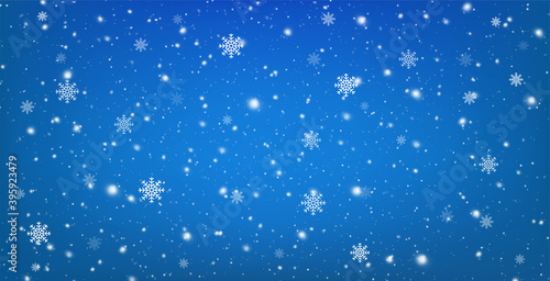 Snowy blue background with falling snowflakes. Christmas winter snowfall with white snow flakes.