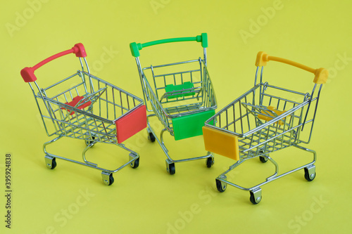 Three empty shopping cart on the yellow background