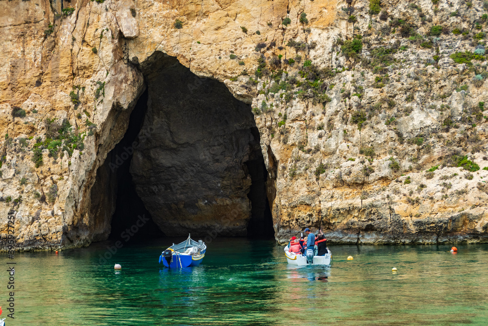 A boat with tourist about to enter the cave which is the exit for the Inland Sea Gozo..