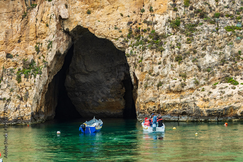A boat with tourist about to enter the cave which is the exit for the Inland Sea Gozo..