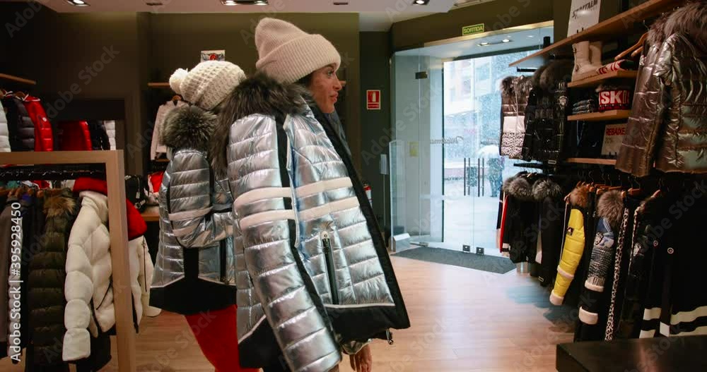 Twins sisters go shopping and have fun during winter vacation. Women try the same winter clothes, perfect for winter activites 4K Twins sisters go shopping and have fun during winter vacation. Women try the same winter clothes, perfect for winter activites 4K