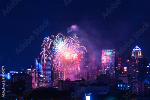 Colorful Firework with cityscape night light view of Bangkok skyline at twilight time..New Year celebration fireworks,  Bangkok city,Thailand.Fireworks light up to sky at Christmas & New Year festival
