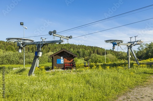 Beautiful landscape view on summer day. Cableway construction slalom ski lift on hill peak on blue sky background. Sweden.