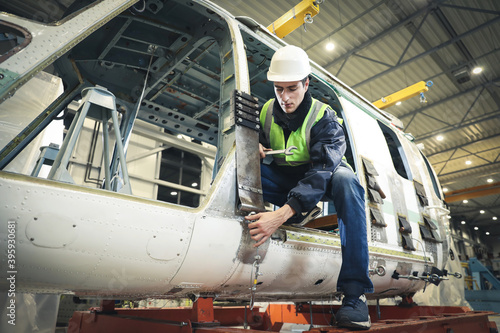 Portrait of a Caucasian man , factory engineer in work clothes controlling the work process at the helicopter manufacturer. 