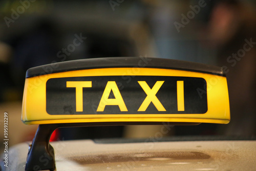 Taxi sign on yellow cab on rainy day