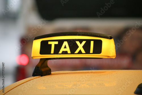 Taxi sign on yellow cab on rainy day