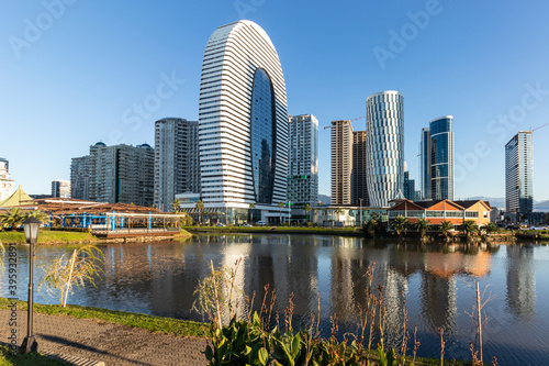An area of growing skyscrapers behind a small pond.