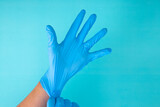 hands wear rubber gloves on a blue background