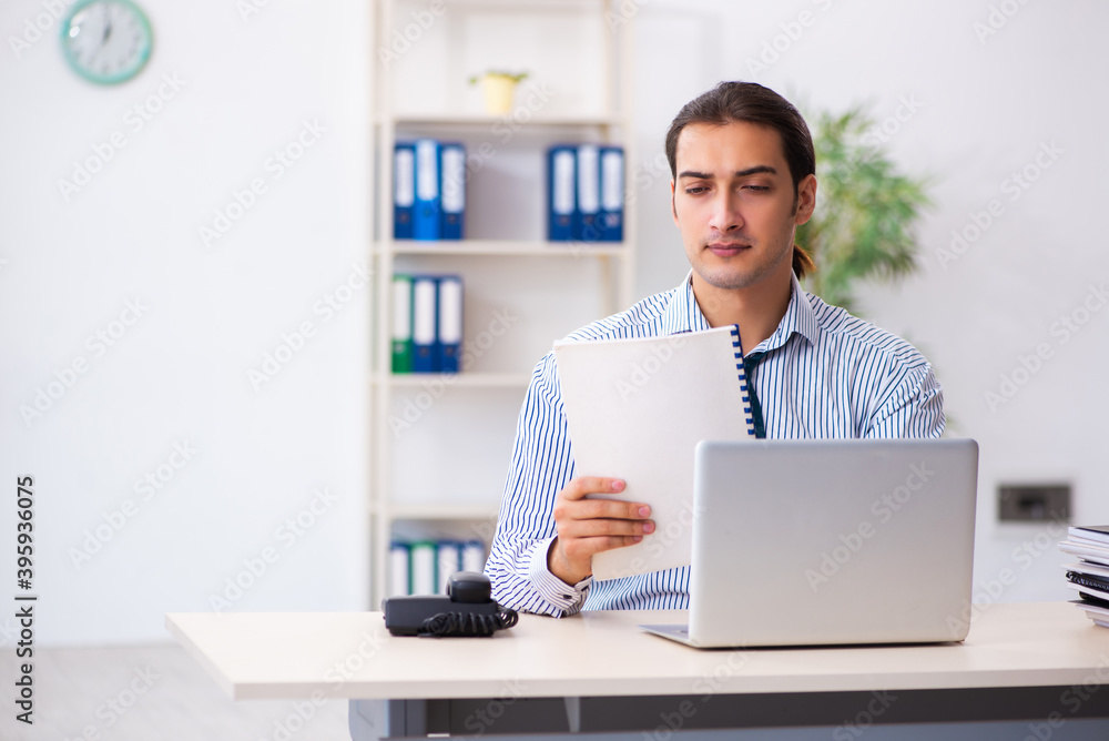 Young male employee working in the office Young male employee working in the office