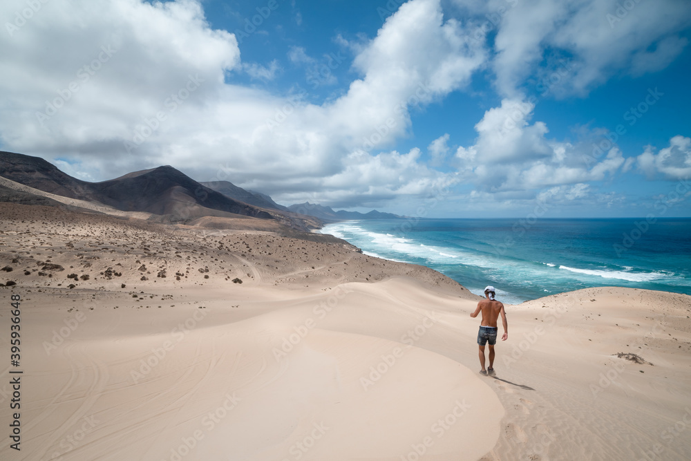 young man walks through the dunes of Jandia towards the mountains of Cofete. Fuerteventura.
young man walks through the dunes of Jandia towards the mountains of Cofete. Fuerteventura.