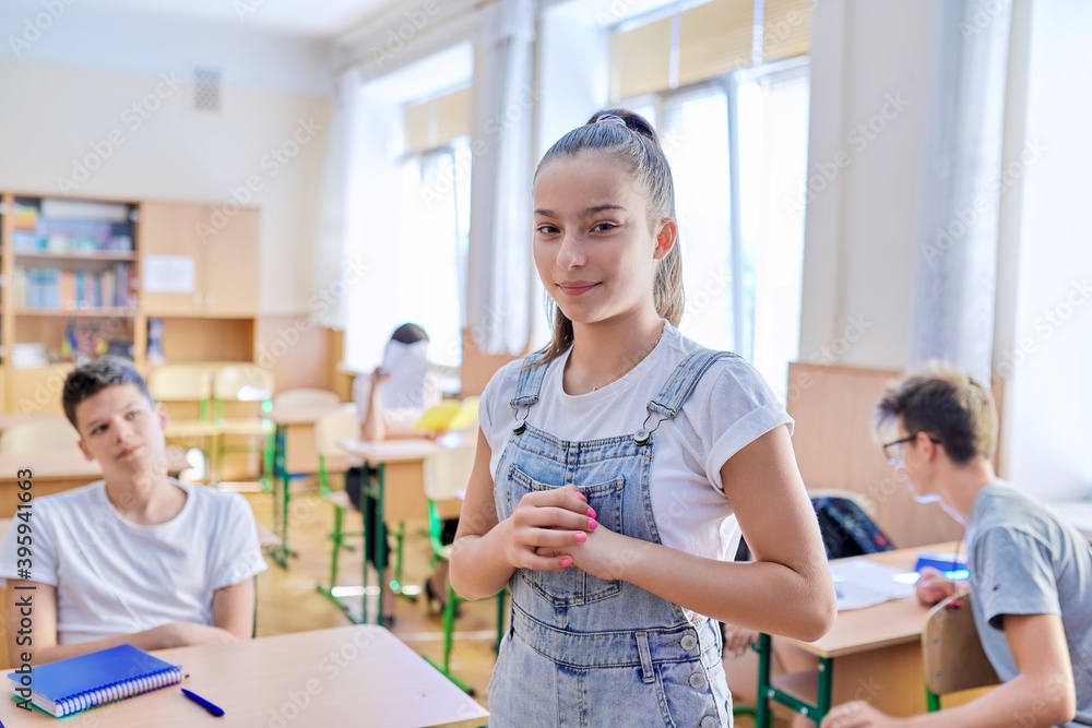 Teenage student taking exam, classroom with study students background Teenage student taking exam, classroom with study students background