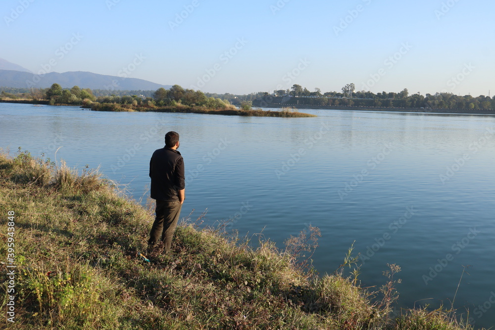 A HUMAN LOOKING TOWARDS A LAKE AT A PLACE DAAKPATTHER. 