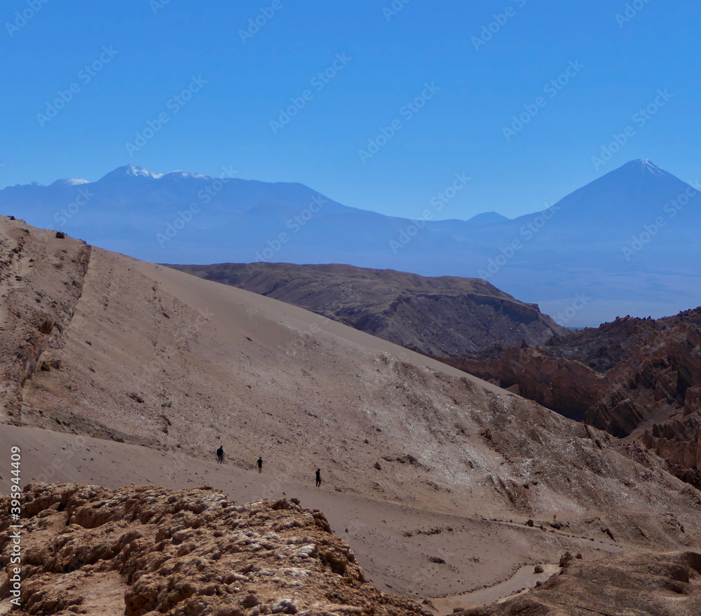 Tourists trekking on lonely trail in valley of the moon, Atacama desert, Chile