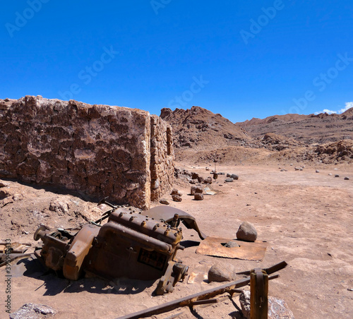 Old historic mine building with machine parts, Atacama desert landscape, Chile
