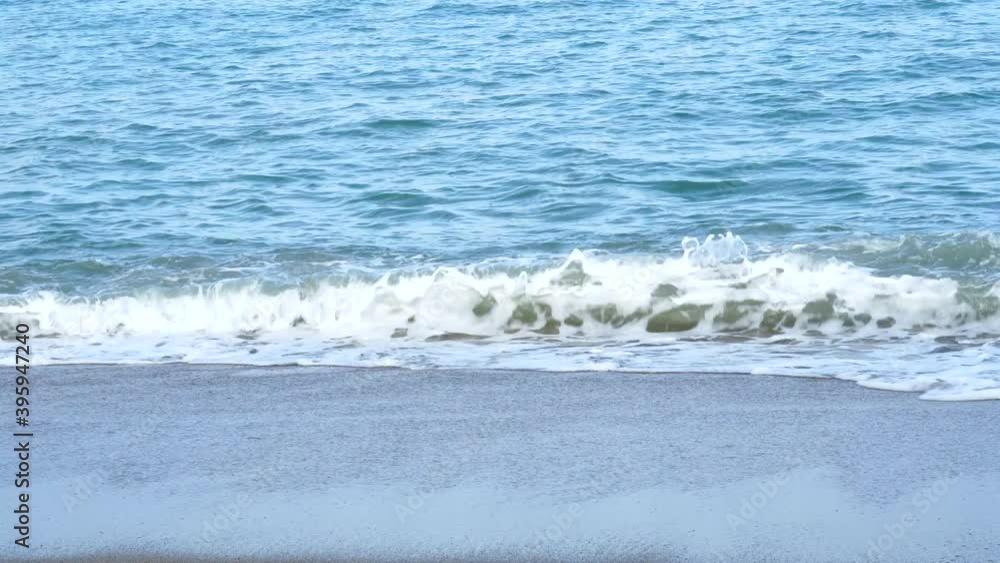 The black sea waves on shore with foam atmosphere on the beach nature background. Ripple water in summer at Thailand tropical island. Vacation travel concept. The black sea waves on shore with foam atmosphere on the beach nature background. Ripple water in summer at Thailand tropical island. Vacation travel concept.