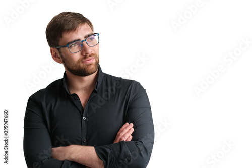 Handsome bearded glasses man in a black shirt on the isolated background. Portrait of young serious businessman