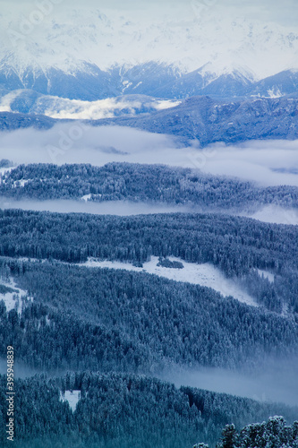 Viste da alta quota della Val di fiemme, con montagne e nuvole basse.