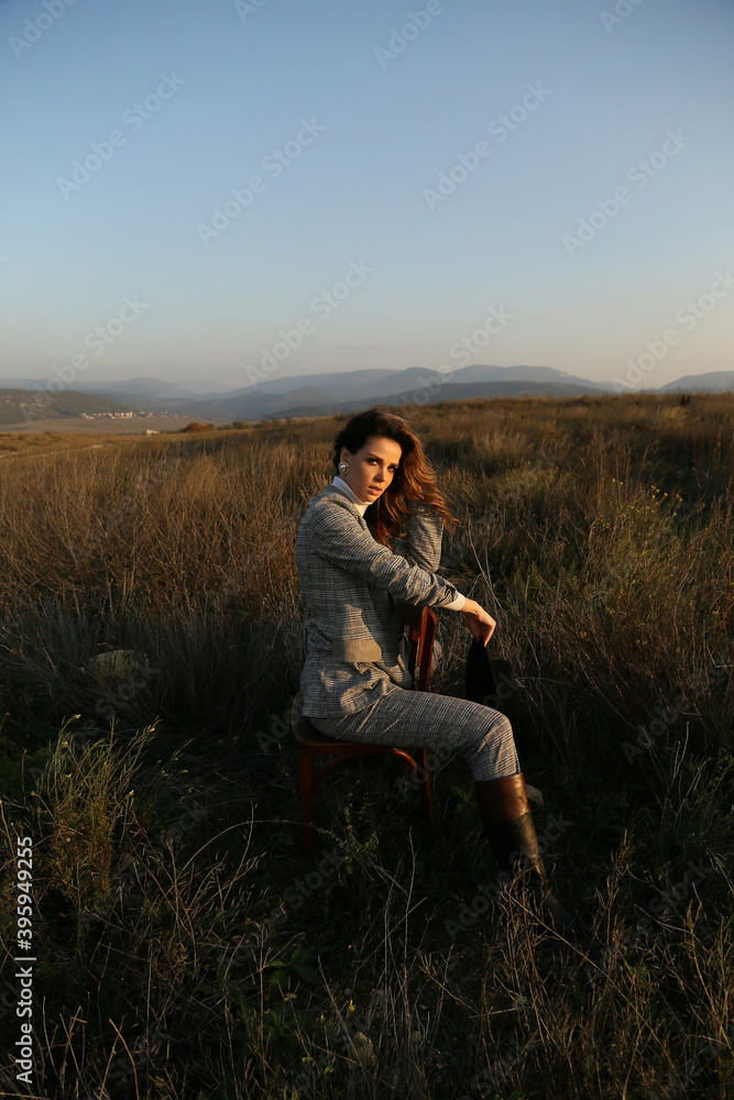 beautiful woman with dark hair in elegant clothes posing in autumn field beautiful woman with dark hair in elegant clothes posing in autumn field