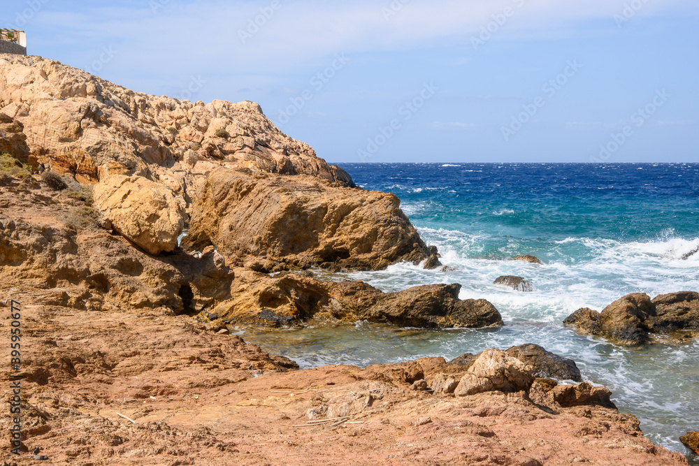 Rocky coast of Koumbara beach located on Ios Island. Cyclades, Greece
