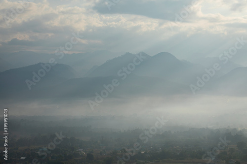 beautiful mountain scape behind small community with mist in the morning at Pai, Mae Hong Son, Thailand © somrerk