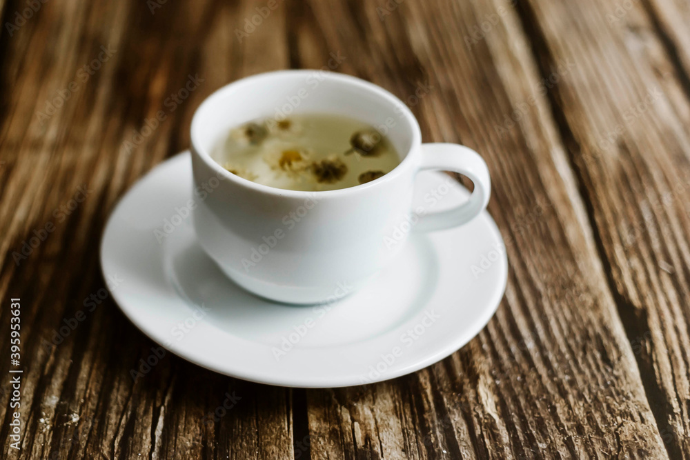 Chrysanthemum tea in cup over the old wooden table background . selective focus Chrysanthemum tea in cup over the old wooden table background . selective focus