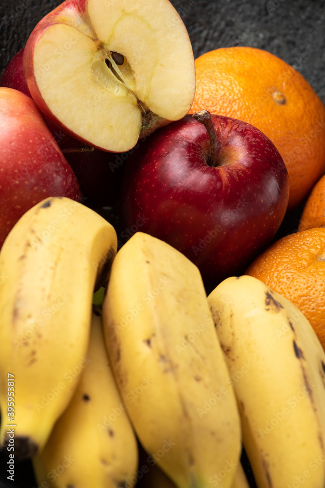 grapes tangerine bananas and apples on a dark pot grapes tangerine bananas and apples on a dark pot