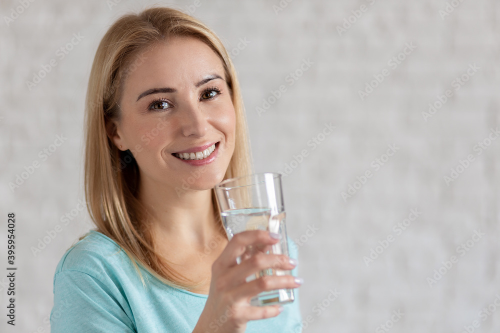 Portrait of happy smiling young woman with glass of fresh water. Healthy lifestyle concept Portrait of happy smiling young woman with glass of fresh water. Healthy lifestyle concept