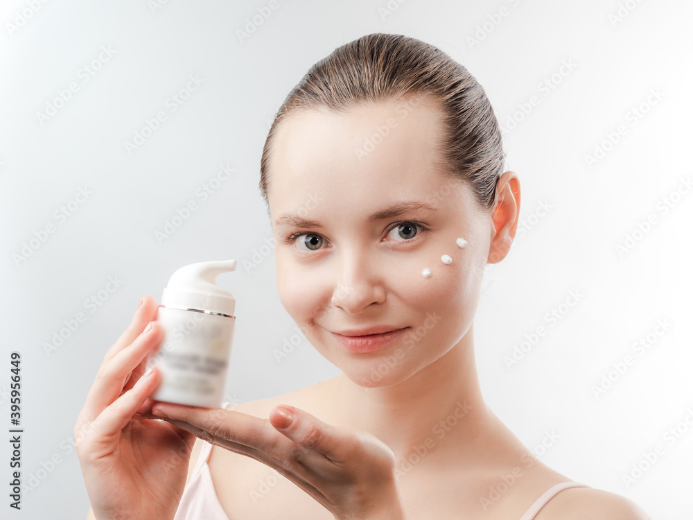 Beautiful Young Woman with Clean Fresh Skin showing the product for skin care. Girl beauty face care. Facial treatment . Cosmetology , beauty and spa. Beautiful Young Woman with Clean Fresh Skin showing the product for skin care. Girl beauty face care. Facial treatment . Cosmetology , beauty and spa.