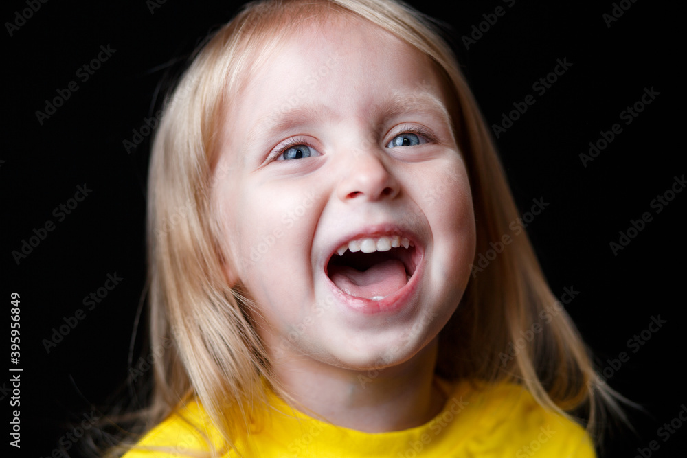 Portrait of a little girl on a dark background. positive child laughs. Portrait of a little girl on a dark background. positive child laughs.