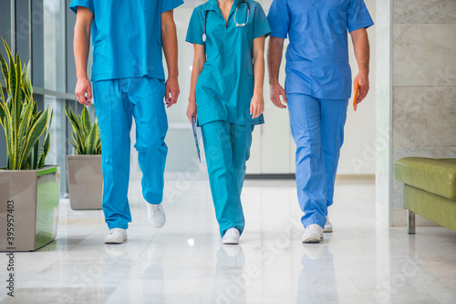 Close up picture of three doctors walking in the corridor